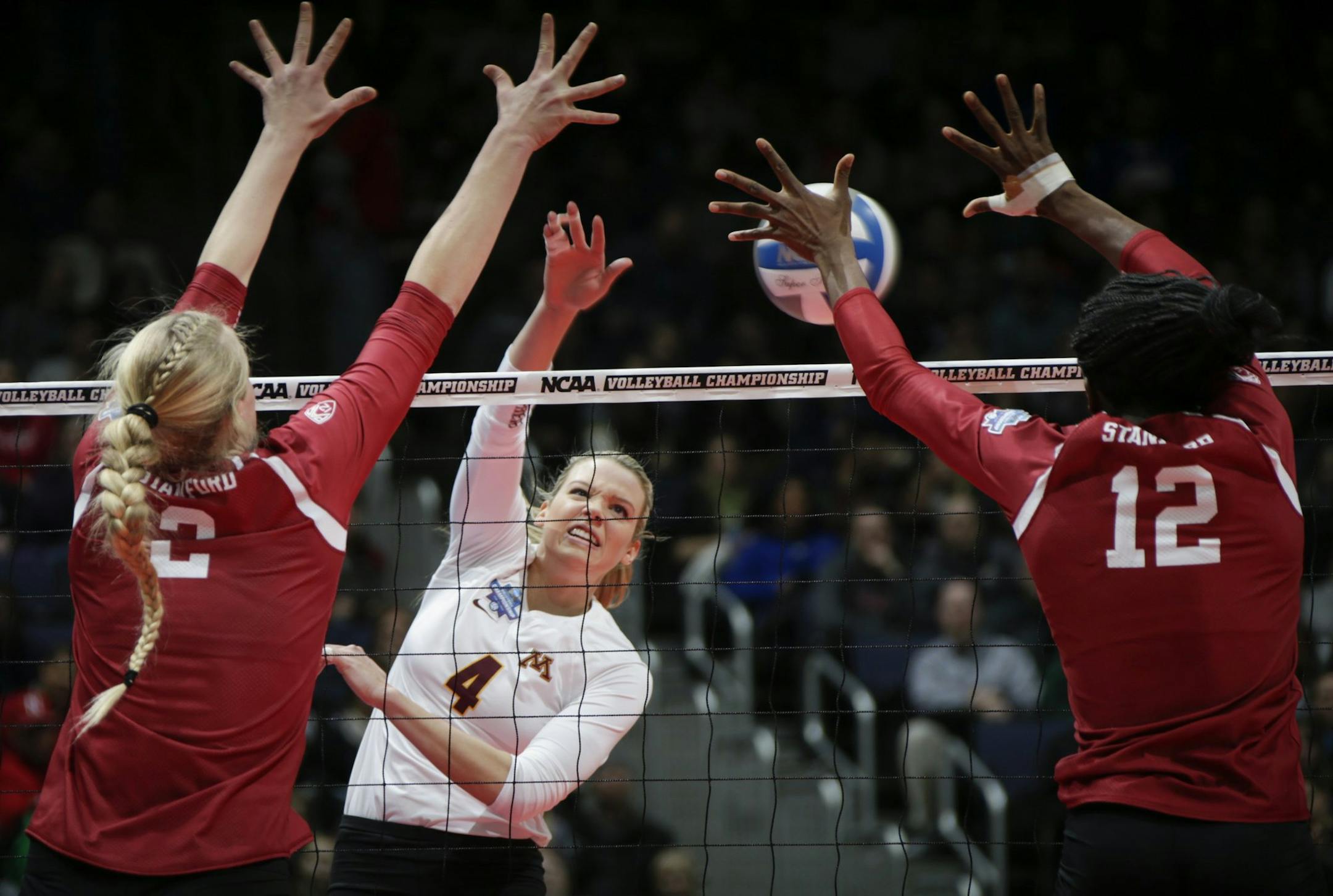 Minnesota's Paige Tapp (4) attempts a kill as Stanford's Kathryn Plummer (2) and Inky Ajanaku (12) look to block during the second set of an NCAA women's volleyball national semifinal at Nationwide Arena in Columbus, Ohio, on Thursday, Dec. 15, 2016. (Joshua A. Bickel/Columbus Dispatch/TNS)
