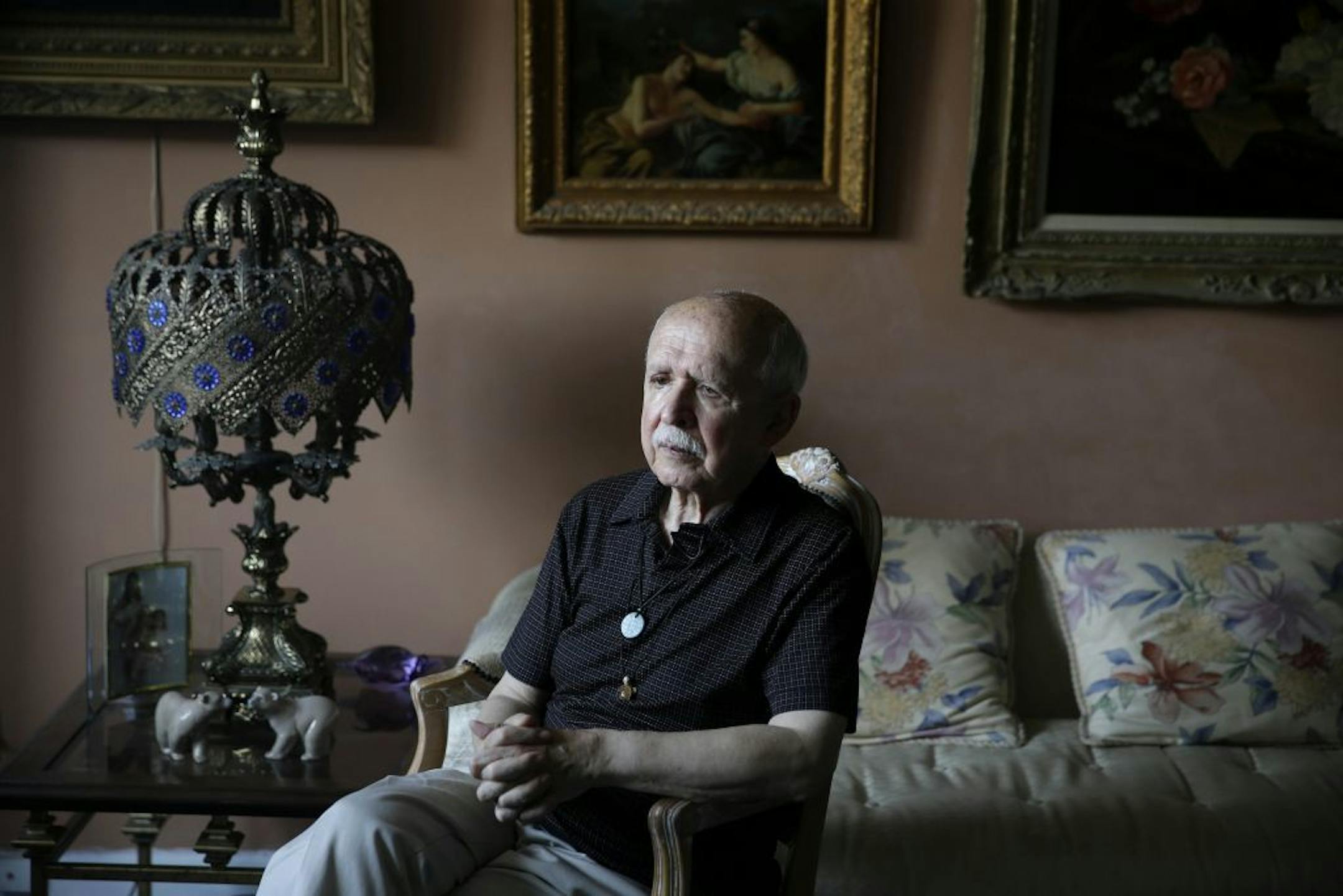 In this Aug. 27, 2014 photo, Arnim Kiwi poses for a portrait in his apartment in New York. Kiwi has been struggling to keep this rent-stabilized apartment ever since his partner died last year and he can't afford to move. He's now living on half the income the couple once had, as his partner died before they were able to get legally married.