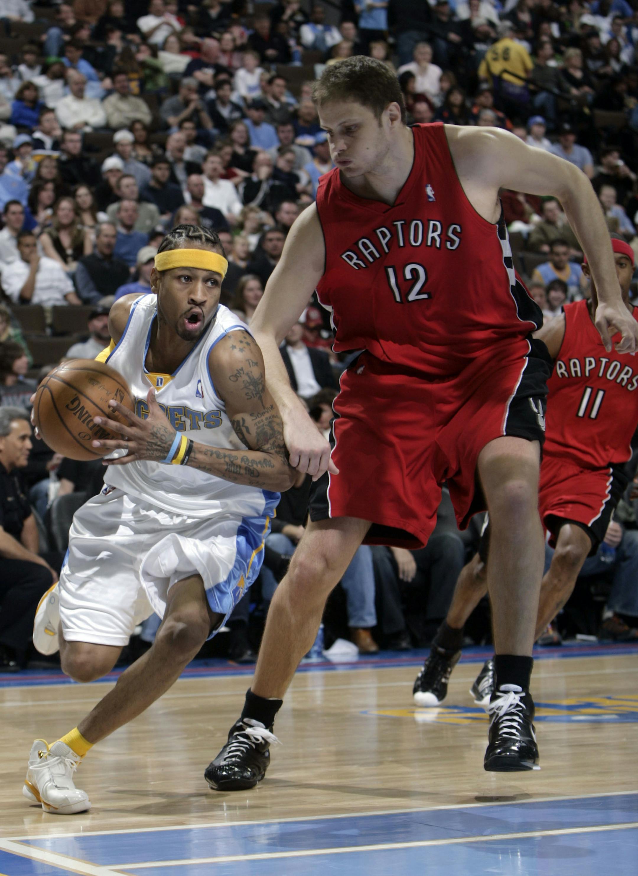Denver Nuggets guard Allen Iverson, left, rushes past Toronto Raptors center Rasho Nesterovic, of Slovenia, in the third quarter of the Nuggets' 137-105 victory in an NBA basketball game in Denver on Friday, March 14, 2008. (AP Photo/David Zalubowski) ORG XMIT: OTKDZ135