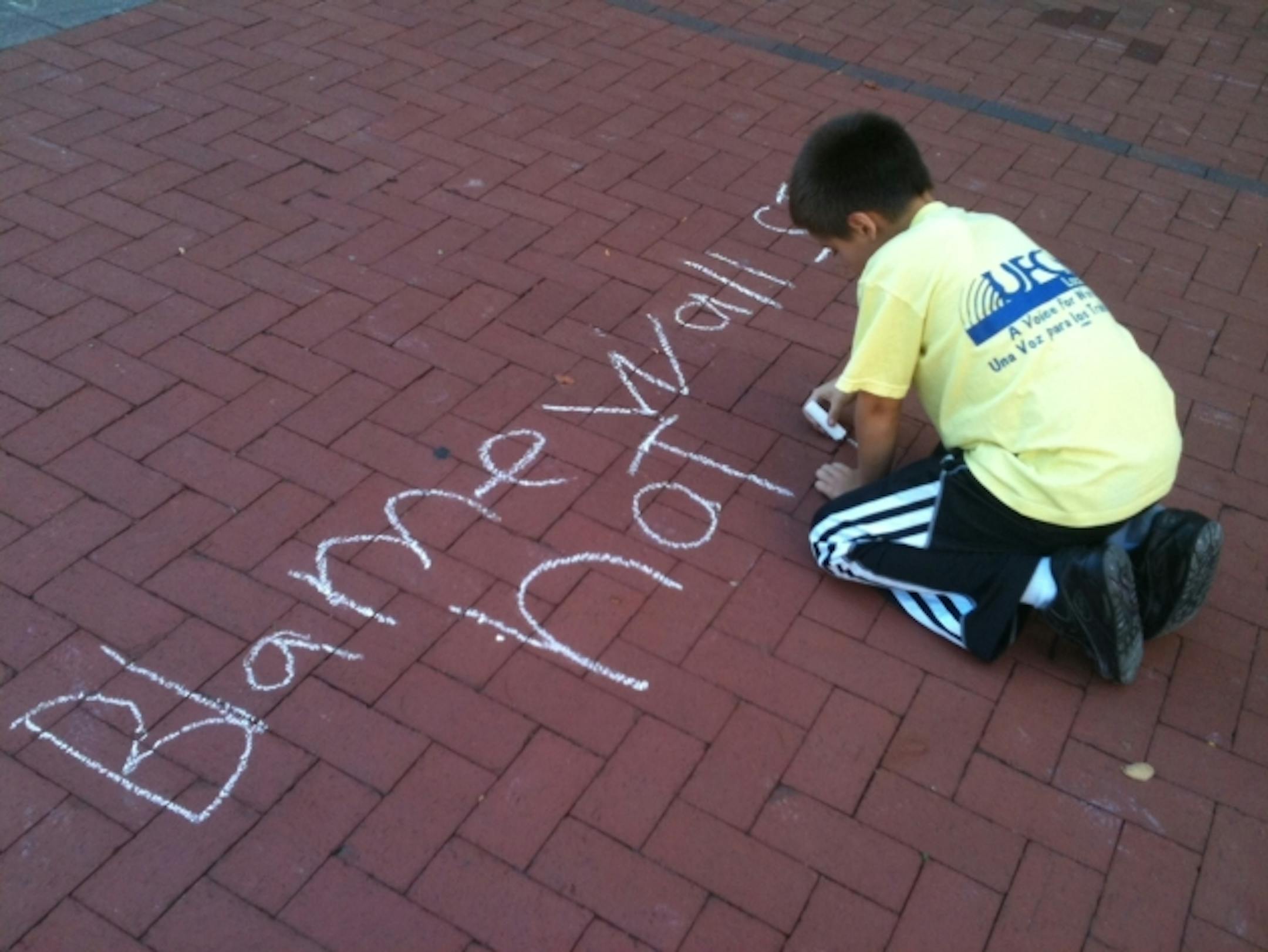 Rafael, 8, writes "Blame Wall Street not my Teacher." His father, Rafael Espinosa, of St. Paul, said, "We expose the kids to knowledge, and they can make a decision what's right and what's wrong."