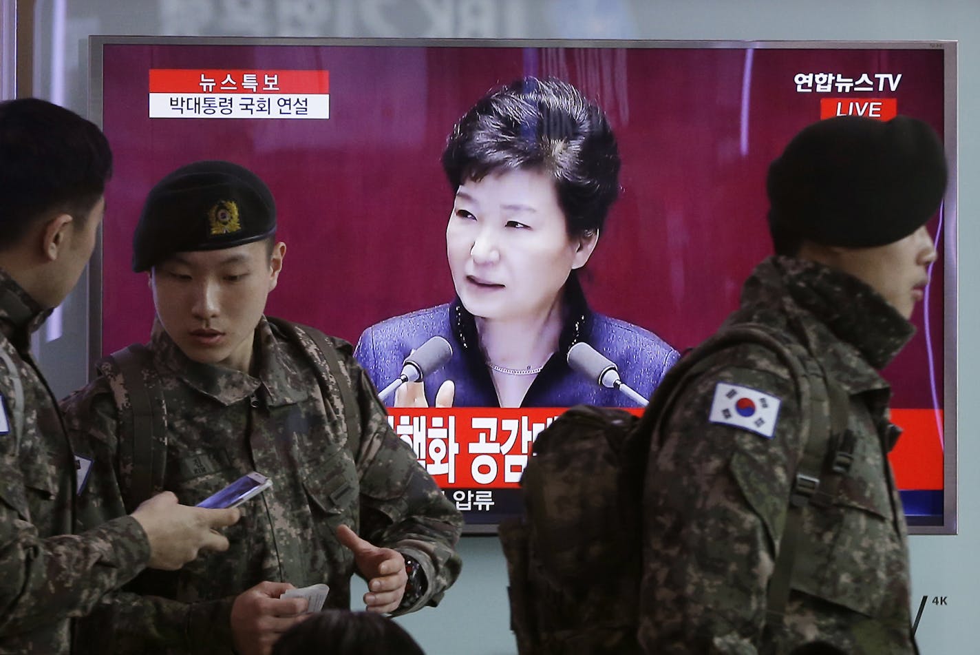 South Korean army soldiers pass by a TV screen showing the live broadcast of South Korean President Park Geun-hye's speech, at the Seoul Railway Station in Seoul, South Korea, Tuesday, Feb. 16, 2016. President Park warns of North Korean collapse if it doesn't abandon its nuclear program. (AP Photo/Ahn Young-joon) ORG XMIT: SEL101