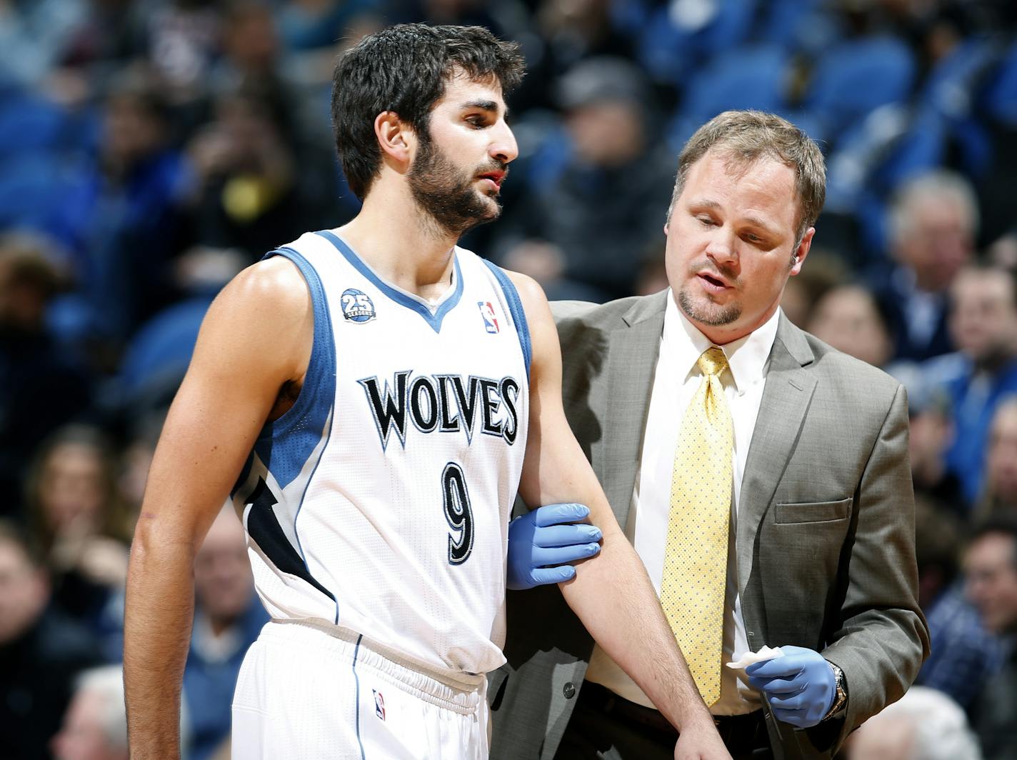 Timberwolves guard Ricky Rubio (9) was looked at by trainer Gregg Farnam in the first quarter.