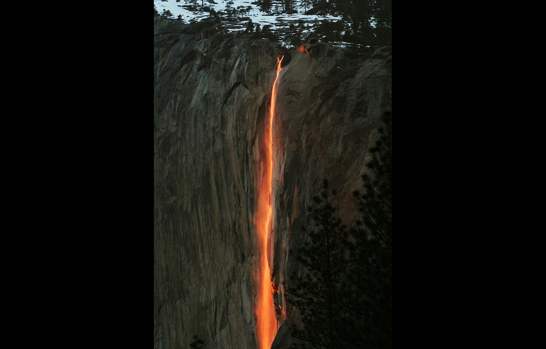 In this Feb. 16, 2010, file photo, a shaft of sunlight creates a glow near Horsetail Fall, in Yosemite National Park, Calif.