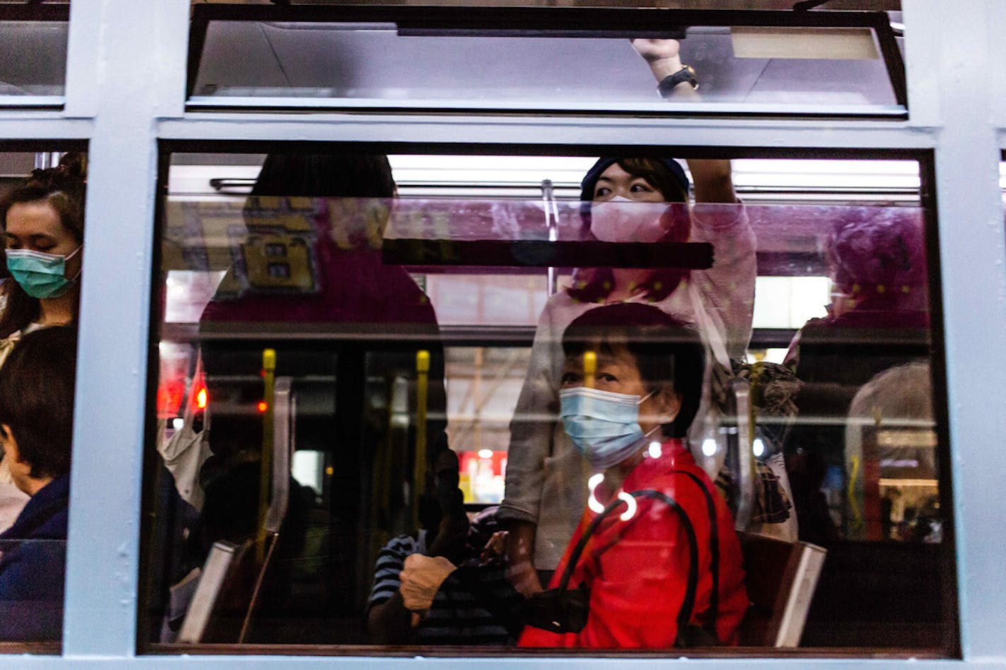 Passengers on a tram wear surgical masks on Jan. 24, 2020, in Hong Kong, China. A woman in Chicago who traveled to China earlier this month has been diagnosed with coronavirus.