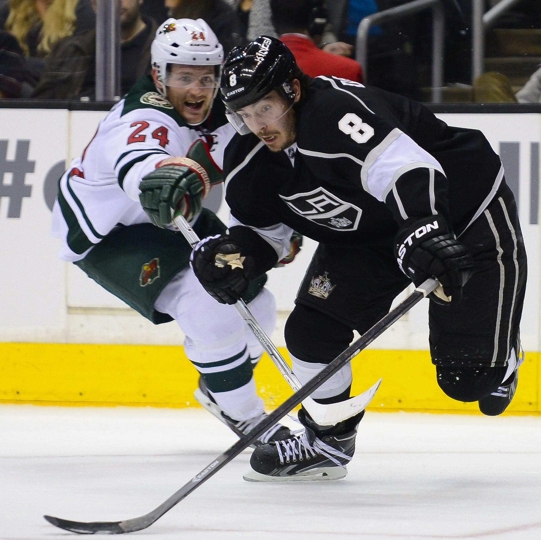 Minnesota Wild left wing Matt Cooke (24) reaches in as Los Angeles Kings defenseman Drew Doughty (8) keeps possession during the second period of an NHL hockey game, Monday, March 31, 2014, in Los Angeles. (AP Photo/Gus Ruelas)