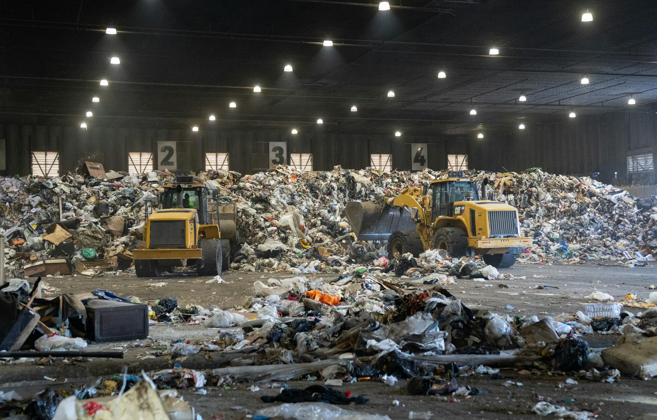 Piles of trash are collected and sorted on the main tipping floor Thursday, Nov. 09, 2023, at Ramsey/Washington Recycling &amp; Energy Center in Newport, Minn. ]