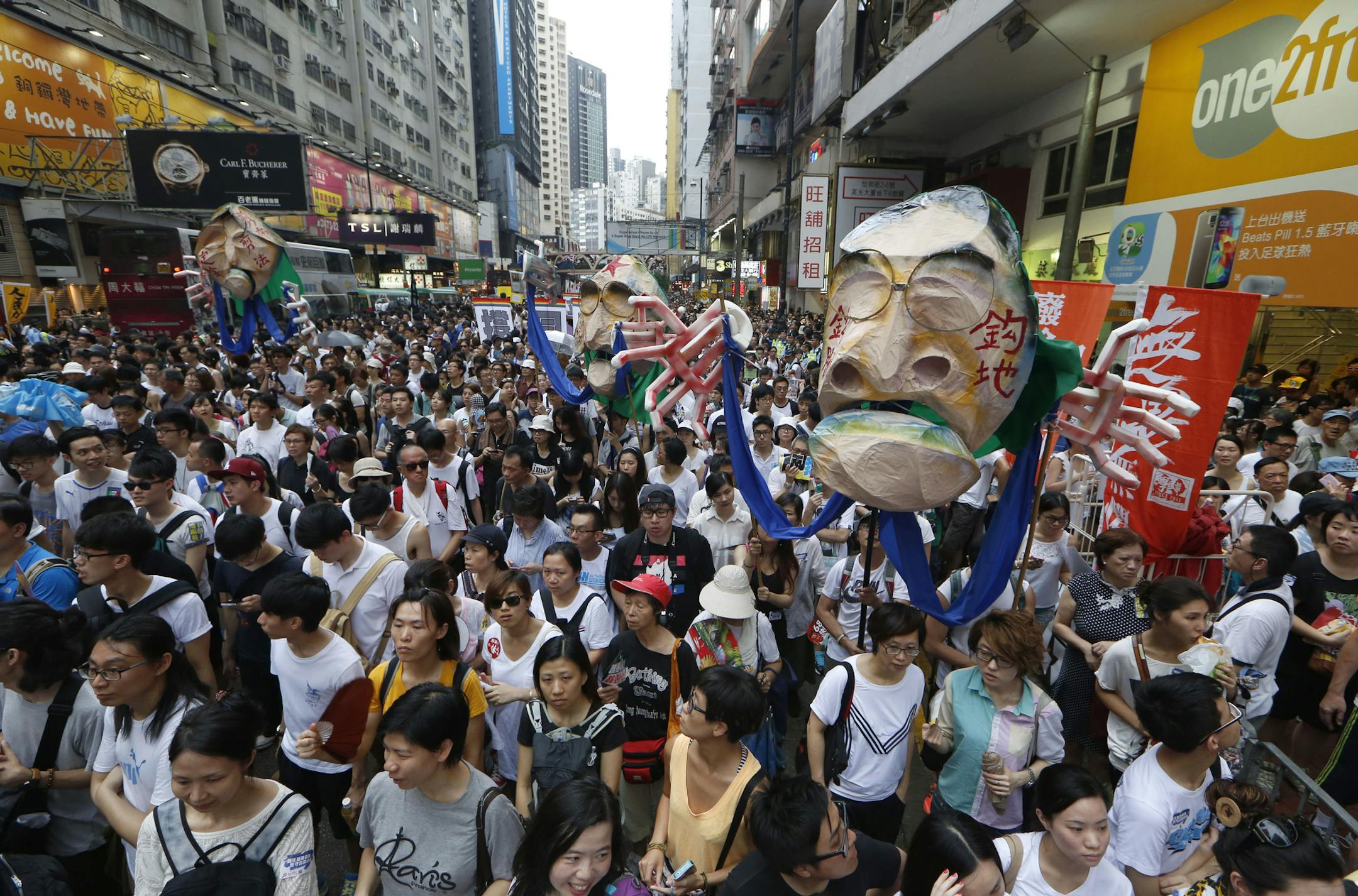 Protesters hold an effigy of Hong Kong Chief Executive Leung Chun-ying as they march during an annual protest in downtown Hong Kong Tuesday, July 1, 2014. Hong Kong residents marched through the streets of the former British colony to push for greater democracy in a rally fueled by anger over Beijing's recent warning that it holds the ultimate authority over the southern Chinese financial center. The protest comes days after nearly 800,000 residents voted in a mock referendum aimed at bolstering