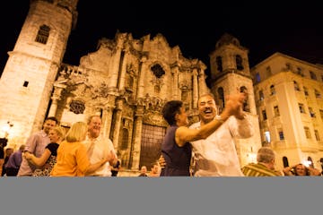 Minnesota Orchestra violinist Deborah Serafini dances with trumpet player Manny Laureano in Plaza de la Catedral in Havana, Cuba on May 14, 2015.