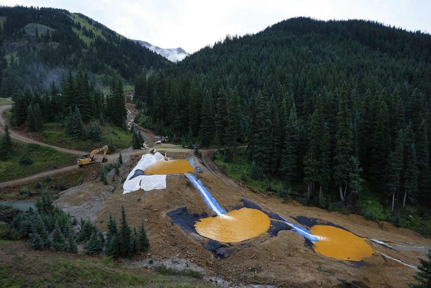 FILE - In this Aug. 12, 2015 file photo, water flows through a series of retention ponds built to contain and filter out heavy metals and chemicals from the Gold King mine chemical accident, in the spillway about 1/4 mile downstream from the mine, outside Silverton, Colo.