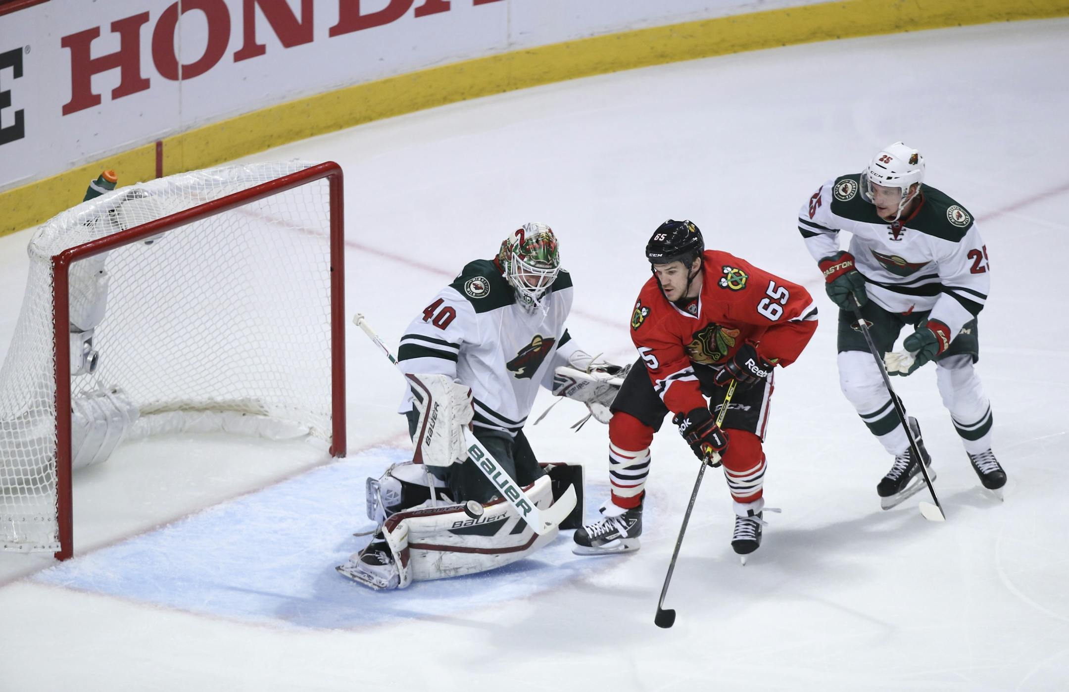 Wild goalie Devan Dubnyk (40) made a first period save and Blackhawks center Andrew Shaw (65) looked for the rebound while the Wild's Jonas Brodin (25) defended Friday night.