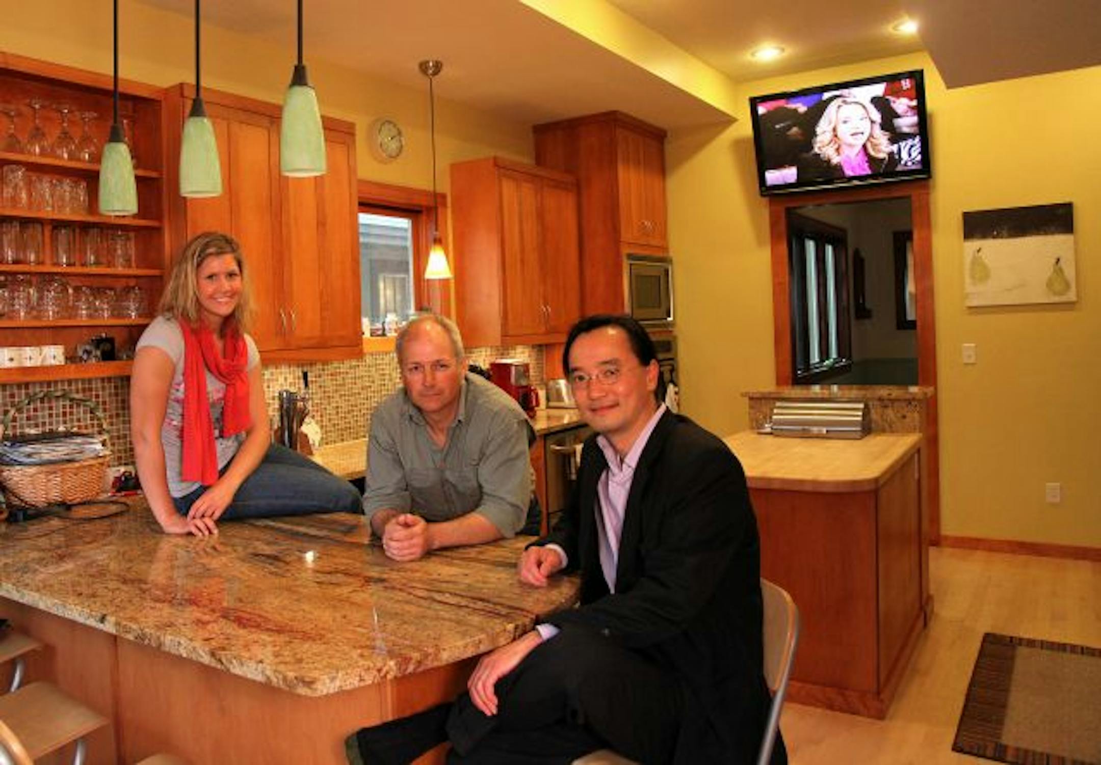 Stan Bratt, center, with his niece Annalise Bratt, a student at Hamline University, who helped with the painting, and architect Tan Nguyen, who lives in the neighborhood.