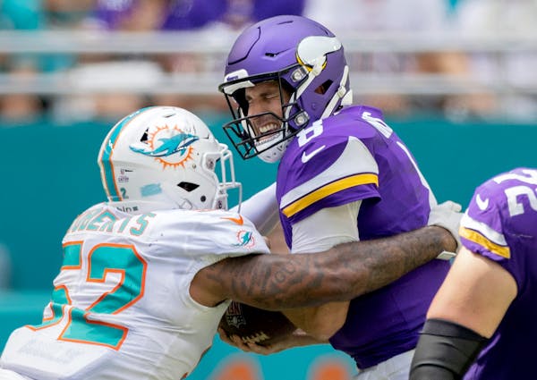 Both teams’ offensive lines struggled Sunday, with Vikings quarterback Kirk Cousins taking three sacks, including this one by Miami’s Elandon Robe