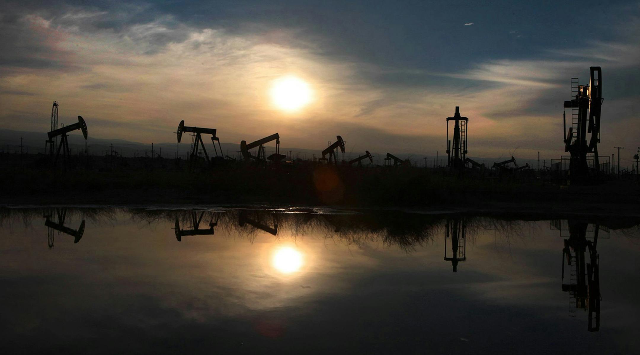 Oil pumps and equipment reflect on water pooled after recent storm in the South Belridge oil field in Kern County, Calif., on March 4, 2014, about 40 miles west of Bakersfield. (Brian van der Brug/Los Angeles Times/TNS) ORG XMIT: 1433069