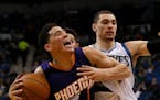Phoenix Suns guard Devin Booker, left, reacts after being fouled by Minnesota Timberwolves guard Zach LaVine, right, during the first half of an NBA b