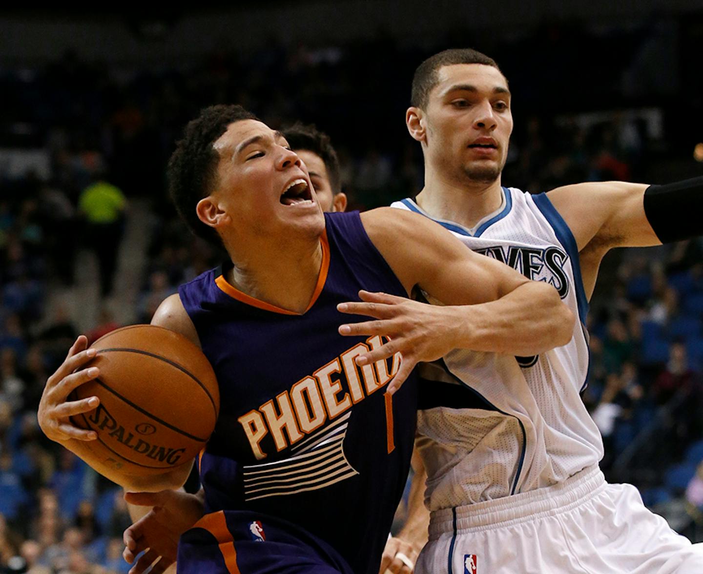 Phoenix Suns guard Devin Booker, left, reacts after being fouled by Minnesota Timberwolves guard Zach LaVine, right, during the first half of an NBA basketball game in Minneapolis, Monday, March 28, 2016.