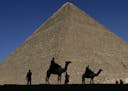 FILE - In this Dec. 12, 2012 file photo, policemen are silhouetted against the Great Pyramid in Giza, Egypt. Scientists have found a previously undisc