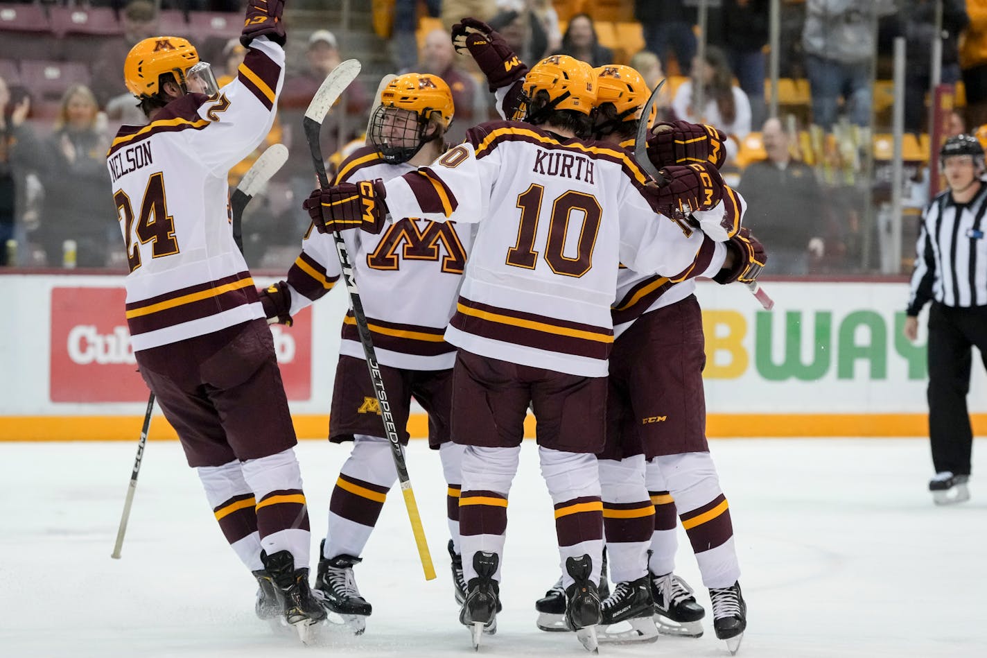 Gophers teammates celebrate with Mason Nevers (18) who scored with an assist from Jaxon Nelson (24), at left, in the second period Friday vs. Notre Dame. Minnesota completed the sweep Saturday.