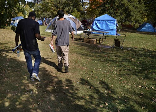 Brandon O'Neil Abrams, 31, left, and Brandon Harrison, 35, walked through Logan Park where they were both living in tents in October. Three encampments remained in Minneapolis parks in December.