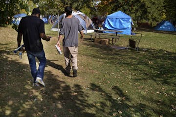 Brandon O'Neil Abrams, 31, left, and Brandon Harrison, 35, walked through Logan Park where they were both living in tents in October. Three encampment