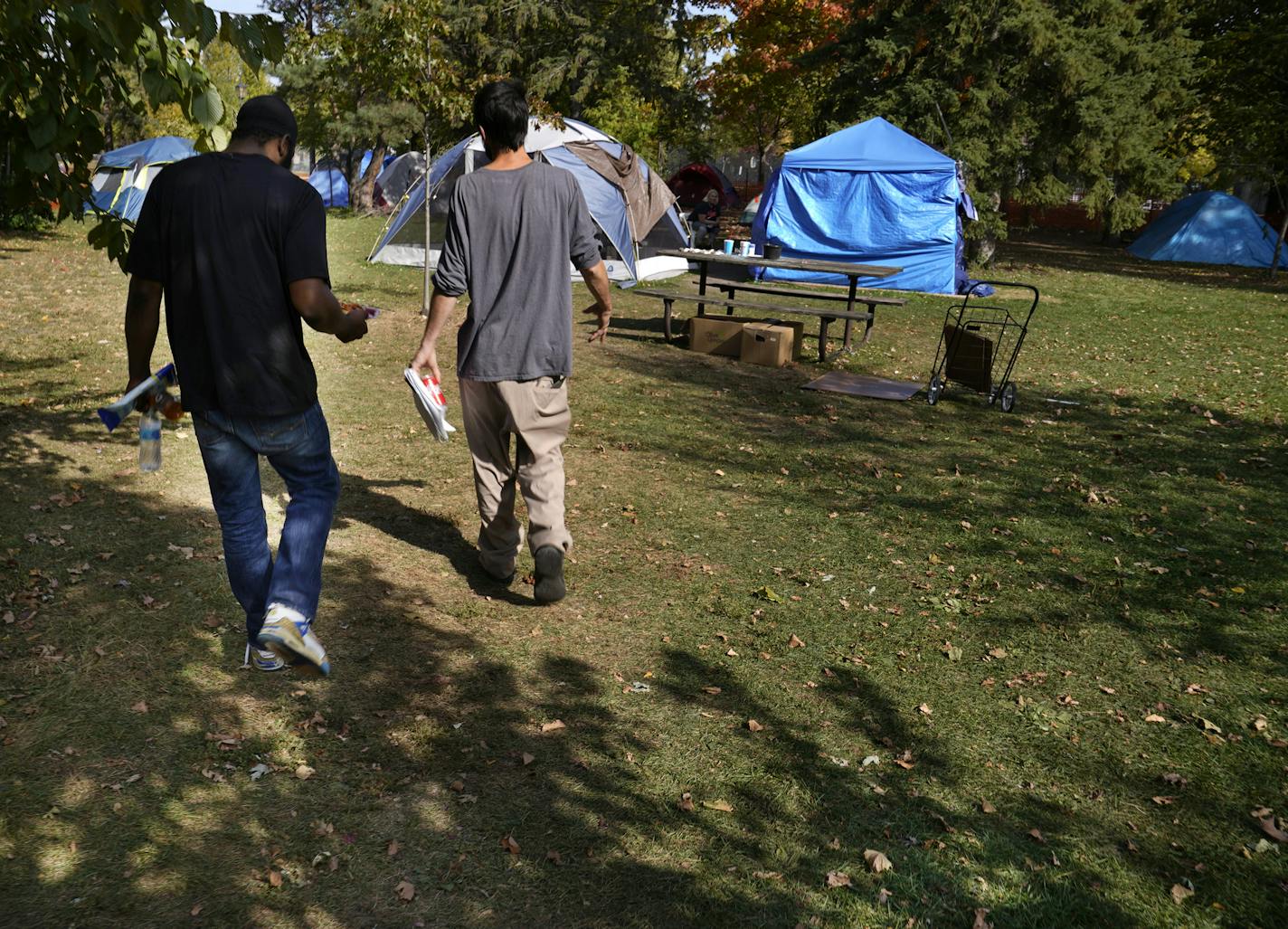 Brandon O'Neil Abrams, 31, left, and Brandon Harrison, 35, walked through Logan Park where they were both living in tents in October. Three encampments remained in Minneapolis parks in December.