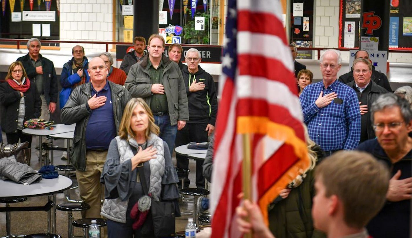 Caucus attendees covered their hearts with their hands as Minnetonka's Boy Scout Troop 207 posted the colors at the beginning of the GOP Caucus at Eden Prairie High School.