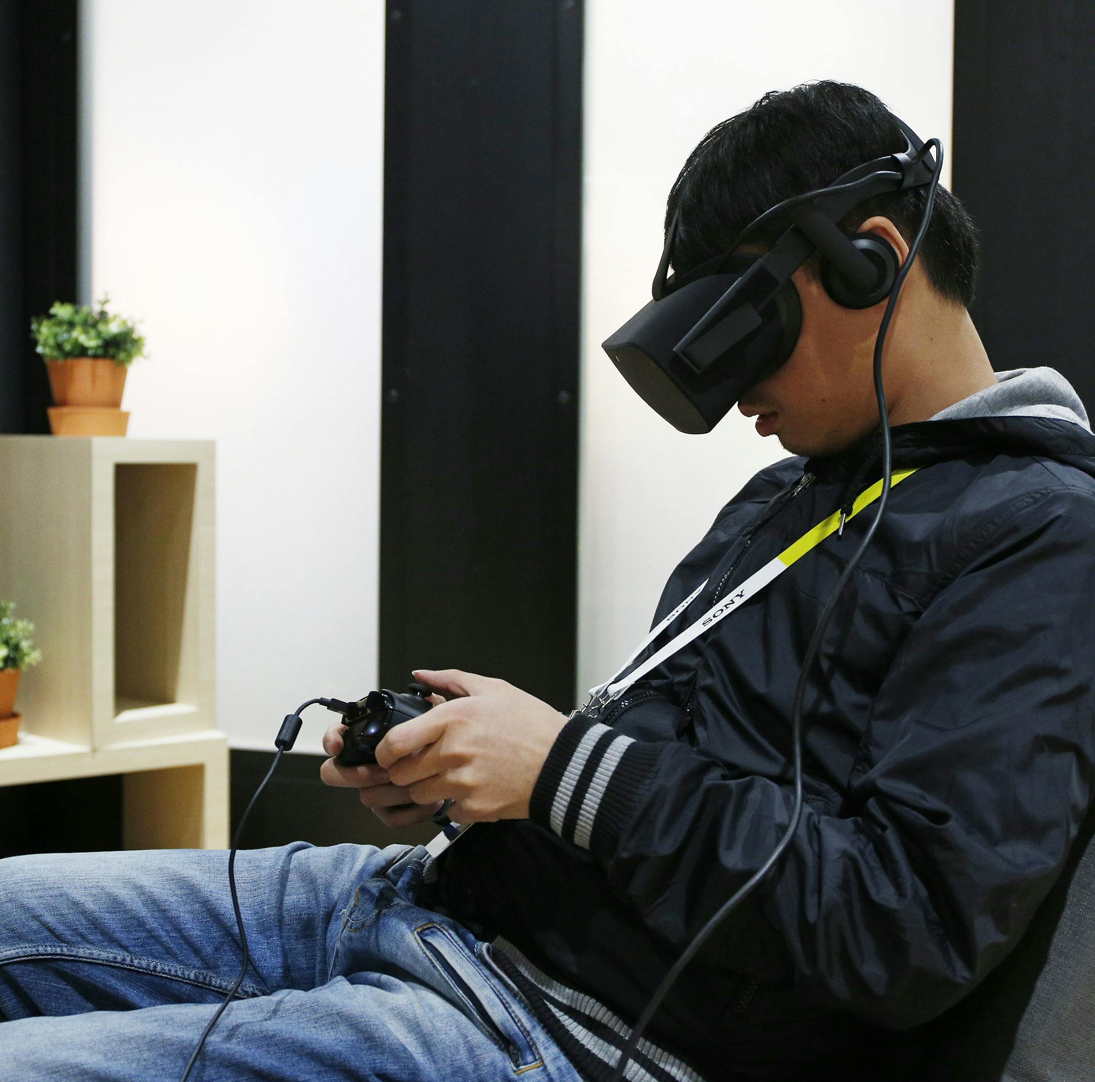 FILE - In this Wednesday, Jan. 6, 2016, file photo, Yining Hou uses the Oculus Rift VR headset at the Oculus booth at CES International in Las Vegas. As Facebook&#xed;s Oculus Rift begins shipping to consumers, reviewers describe the virtual-reality headset as a device that immerses you, yet it still has a ways to go. (AP Photo/John Locher, File)