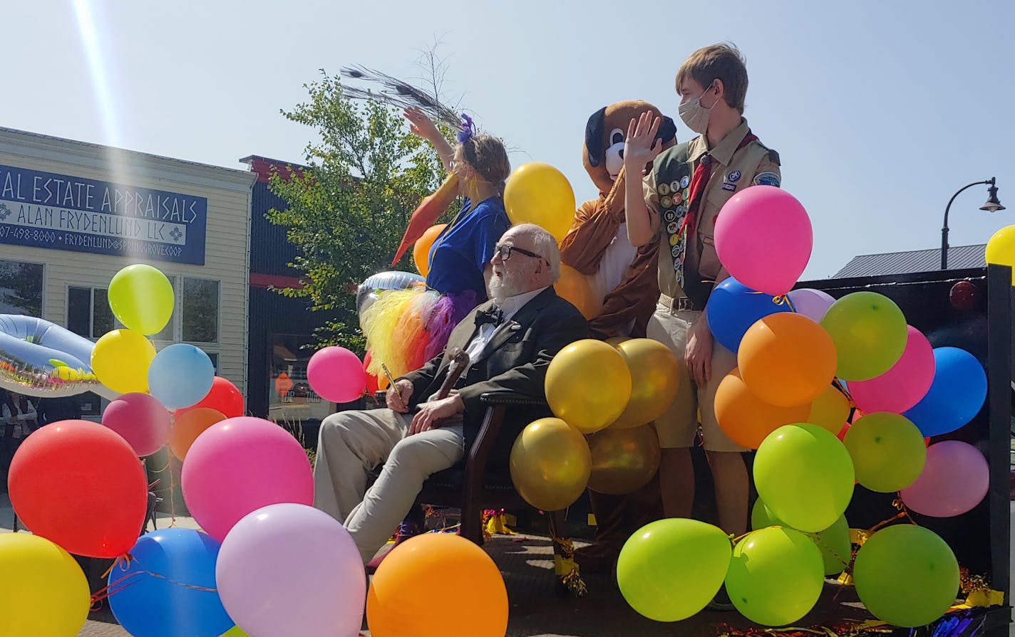 Ed Asner, surrounded by Spring Grove locals dressed as ÒUpÓ characters, relishes his role Sunday as special guest in the townÕs parade. (Neal Justin/Star Tribune)