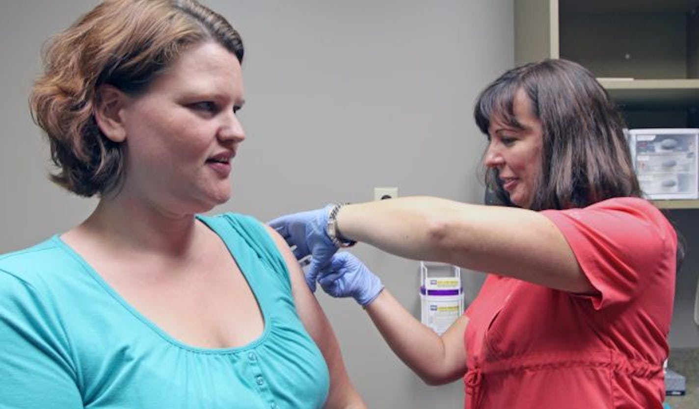 Nurse Helena Gustafson gave Stephanie Pelach a seasonal flu shot at the Fairview clinic in New Brighton. Pregnant women such as Pelach are being urged to get the H1N1 vaccine as soon as it arrives.