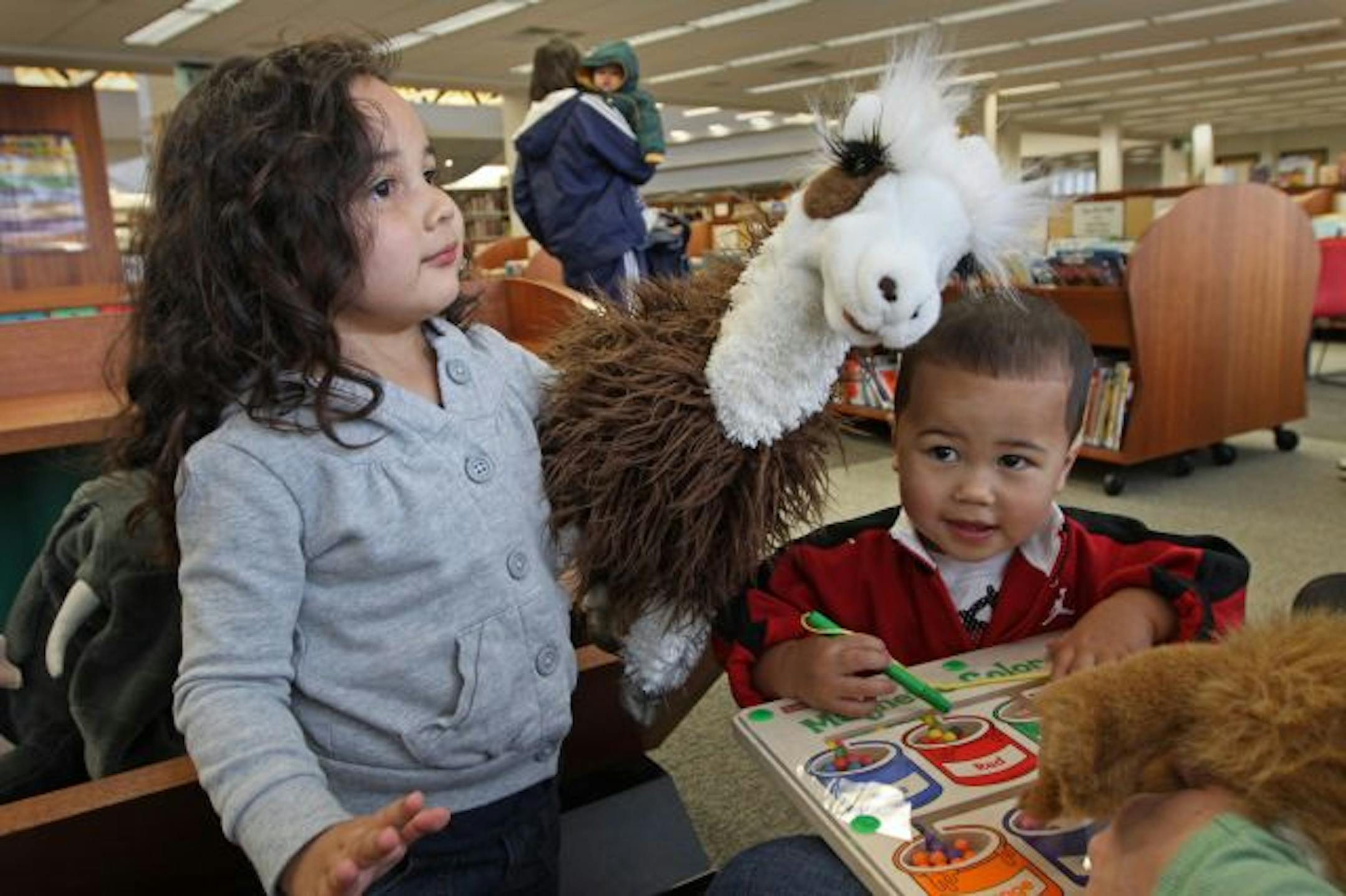 (left to right) Maile, age-3 and Lincoln, age-1 1/2, played with the puppet stuffed animals during a visit to the Eden Prairie library with their mom, Alisa Tahi of Eden Prairie. The beloved creatures are being removed by the Hennepin library system due to the swine flu scare. The library will continue to provide wooden and plastic educational toys that can be more easily cleaned than the stuffed animals.