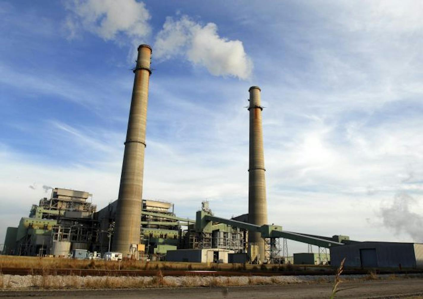 Smoke stacks from the NRG power plant located just outside of Jewett, Texas tower over Texas Highway 39, Nov. 28, 2007. The plant provides 250 full-time jobs for Limestone county. Jewett is one of four towns, two in Texas and two in Illinois, competing for the new state-of-the-art FutureGen power plant developers say would emit almost no pollution, turning coal into gas while capturing and storing climate-changing carbon dioxide deep underground.