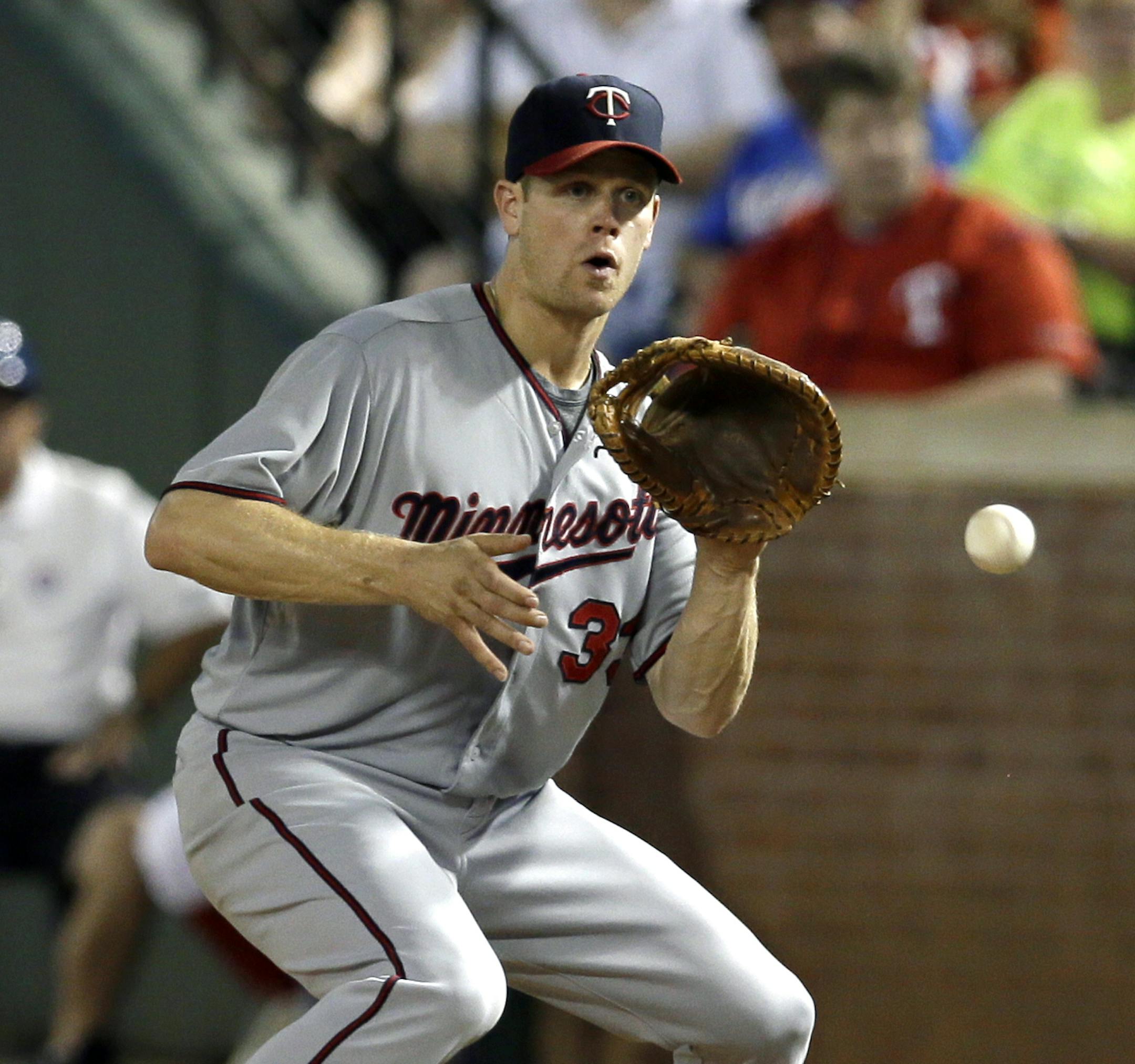 Minnesota Twins first baseman Justin Morneau fields a ground out by Texas Rangers' A.J. Pierzynski in the eighth inning of a baseball game, Friday, Aug. 30, 2013, in Arlington, Texas. Chris Herrmann hit a tying, two-run homer to break up Yu Darvish's no-hit bid in the seventh inning, Morneau followed with a home run and the Twins defeated the Rangers 3-2. (AP Photo/Tony Gutierrez) ORG XMIT: MIN2013083023155496