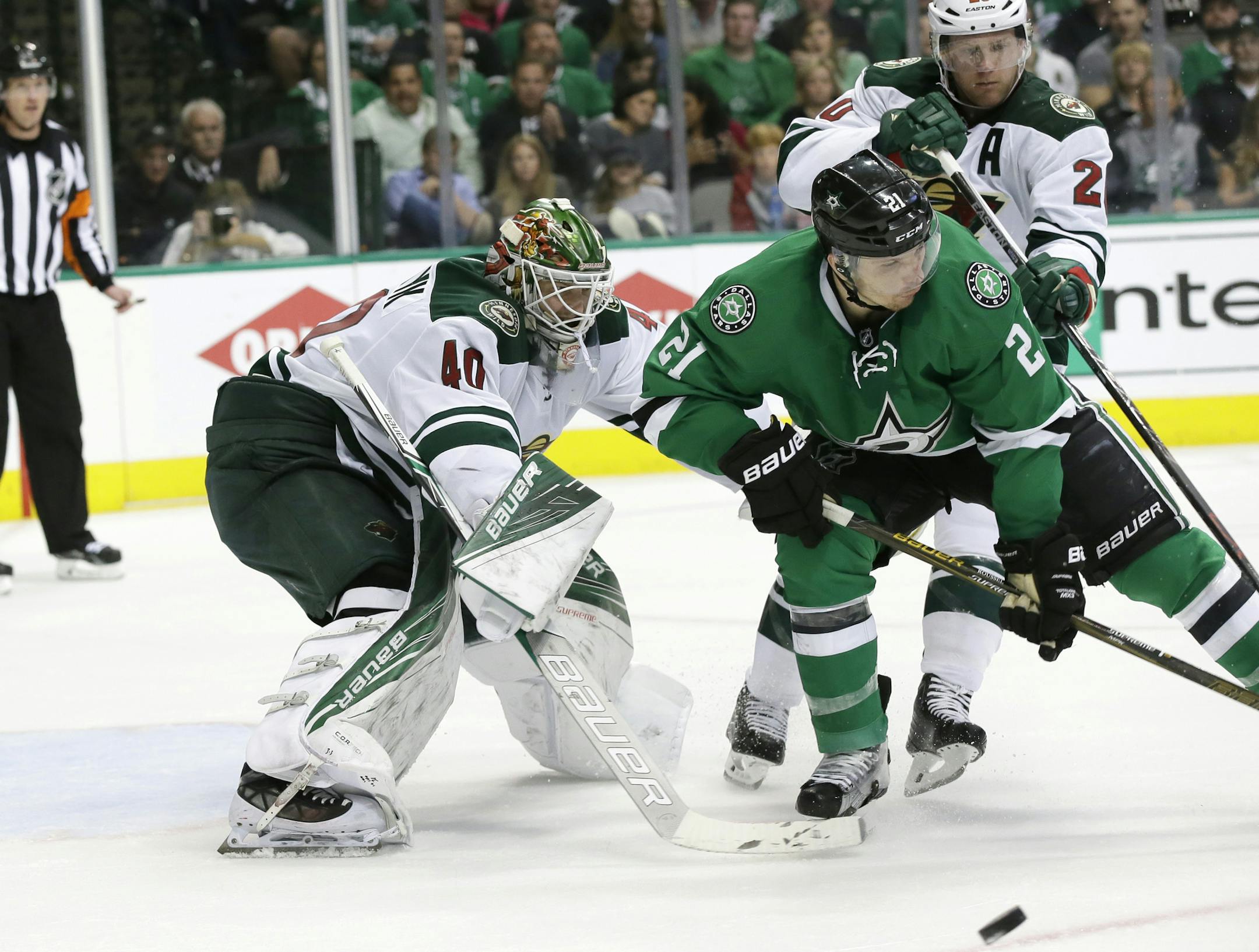 Minnesota Wild goalie Devan Dubnyk (40) and defenseman Ryan Suter (20) defend the goal against Dallas Stars left wing Antoine Roussel (21) during the third period in Game 2 in the first round of the NHL Stanley Cup playoffs Saturday, April 16, 2016, in Dallas. The Stars won 2-1. (AP Photo/LM Otero)