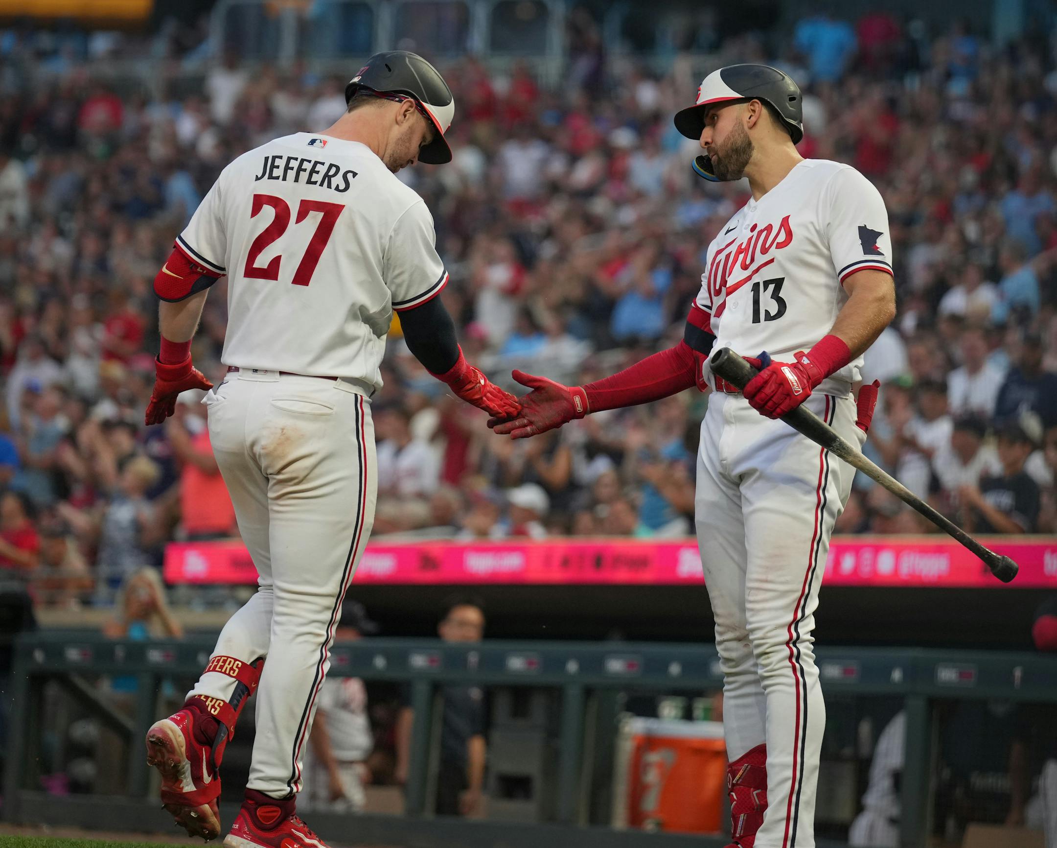 Minnesota Twins catcher Ryan Jeffers (27) is greeted by eft fielder Joey Gallo (13) at home plate after Jeffers hit a home run in the fifth inning against the Arizona Diamondbacks.