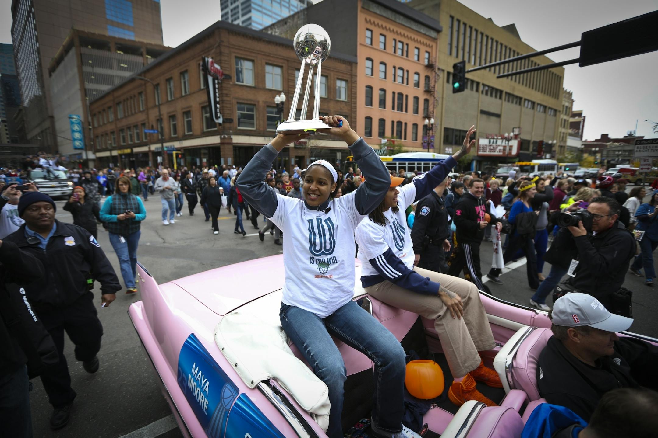 Lynx player Maya Moore held up the championship trophy as she rode a float with Seimone Augustus during a championship celebration parade for the WNBA champions on Monday, October 14, 2013, through downtown Minneapolis.