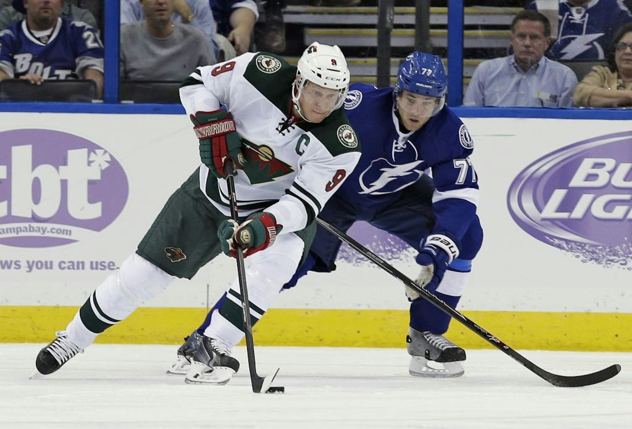 Minnesota Wild center Mikko Koivu (9), of Finland, moves the puck around Tampa Bay Lightning defenseman Victor Hedman (77), of Sweden, during the second period of an NHL hockey game Thursday, Oct. 17, 2013, in Tampa, Fla.