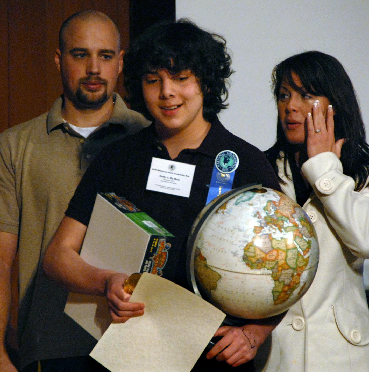 Cody DuBois, a seventh-grader at Emerson Spanish Language Immersion Learning Center in Minneapolis, won the Minnesota State Geographic Bee and an armload of prizes, including $100 and a globe. With him were his dad, Andy DuBois, and stepmom, Amanda DuBois.