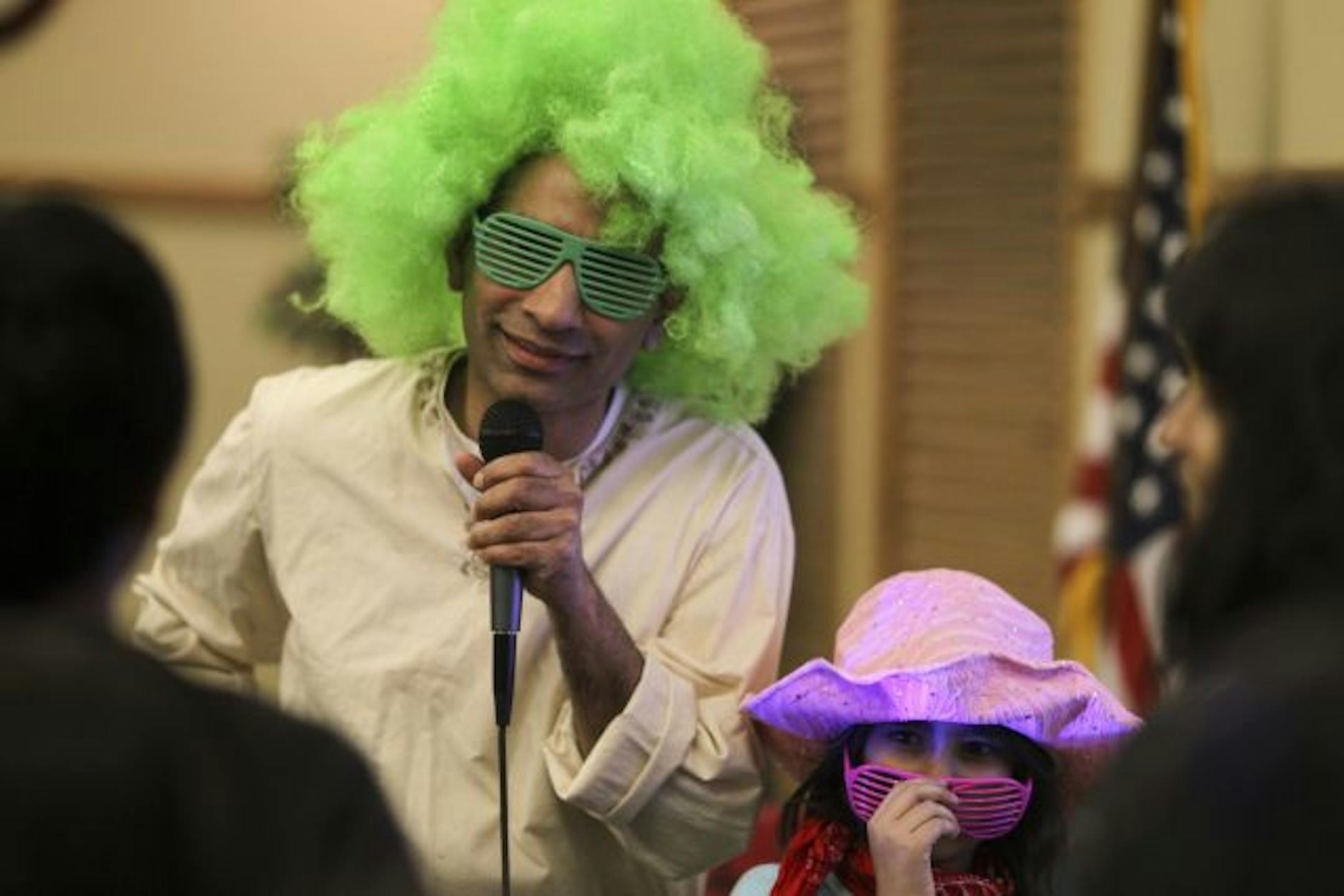 Mateen Ali was the emcee of the game portion of Family Fun Night during the Northwest Islamic Community Center meeting Friday night. All the games called for a child to participate together with a parent. Ali's daughter, Sanah, right, was assisting him.