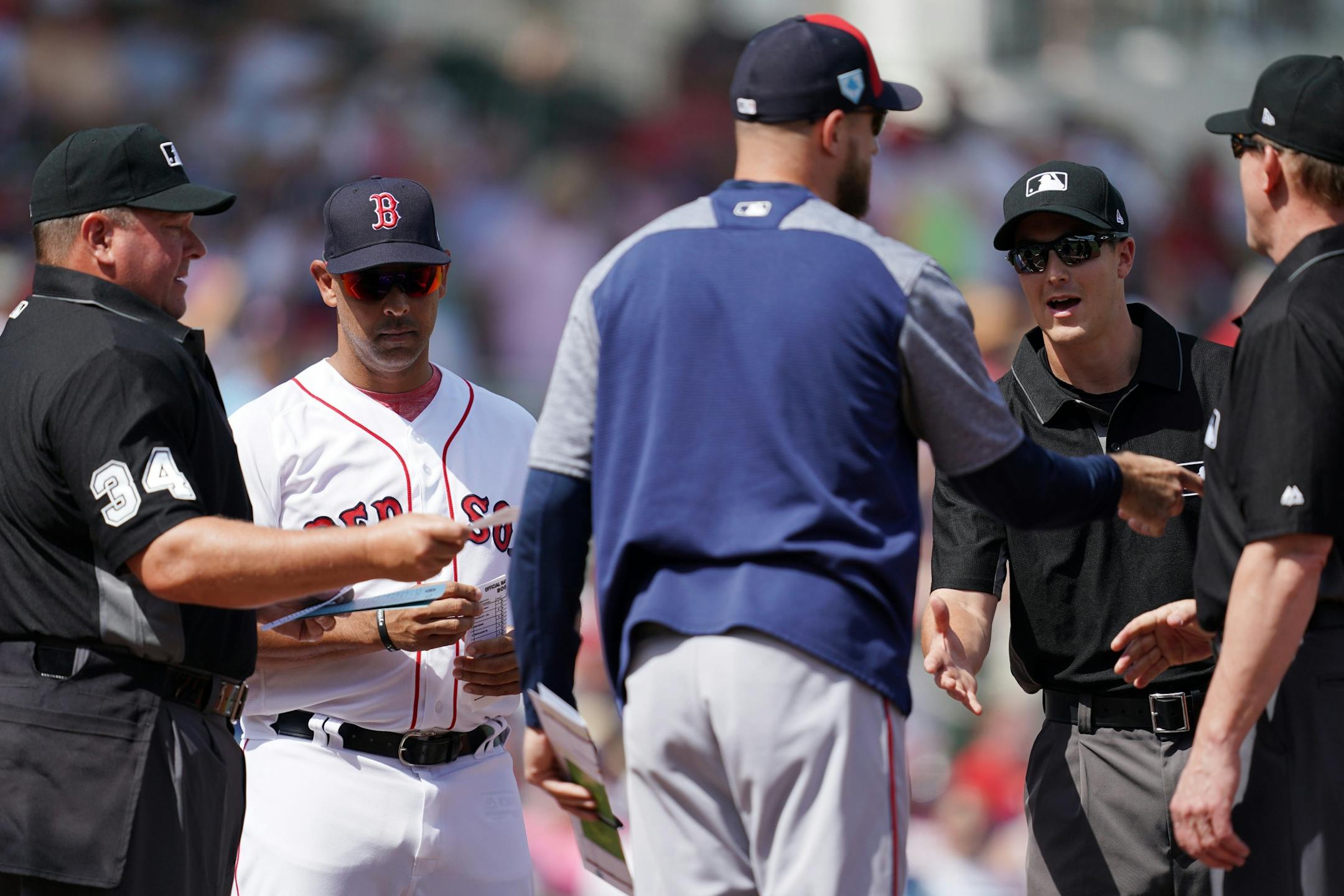 Minnesota Twins manager Rocco Baldelli (5) greeted umpires as Boston Red Sox manager Alex Cora stood nearby Sunday's game.