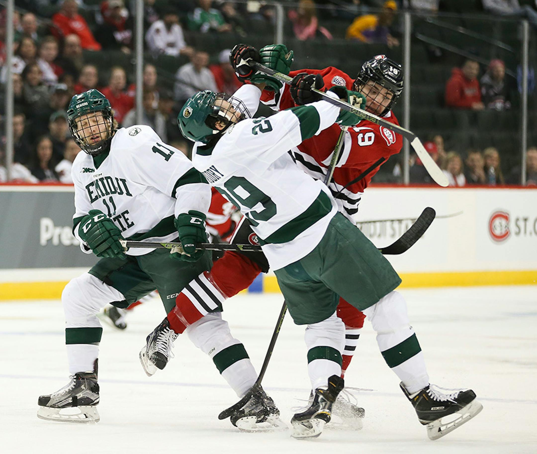 Beavers defenseman Justin Baudry (29) and Huskies forward Mikey Eyssimont (19) collided in the first period Sunday afternoon with Bemidji forward Nate Arentz (11) nearby.