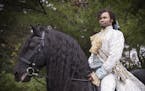 Actor David Murray poses with El Dante, a Friesian stallion, at Carisbrooke Farm in Stillwater.