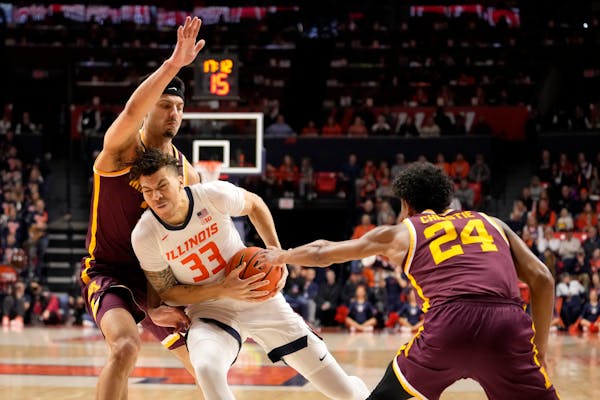 Illinois' Coleman Hawkins drives to the basket between the defense of the Gophers' Cam Christie (24) and Dawson Garcia during the first half of the Il