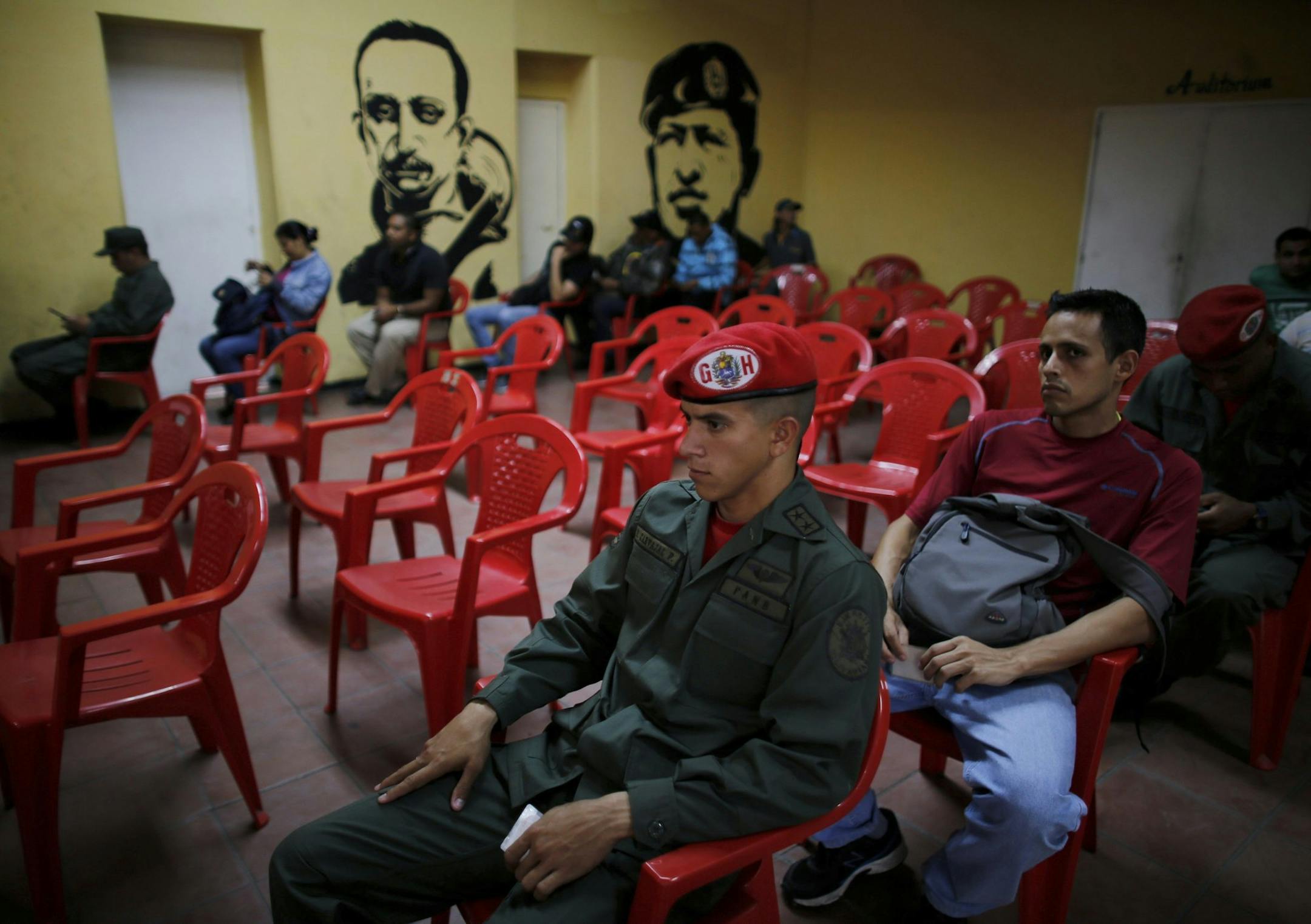 Voters wait to cast their ballots next murals of Venezuelan Independence hero Ezequiel Zamora, left, and the late Venezuelan President Hugo Chavez at a polling station in Caracas, Venezuela, Sunday, July 30, 2017. President Nicolas Maduro asked for global acceptance on Sunday as he cast an unusual pre-dawn vote for an all-powerful constitutional assembly that his opponents fear he'll use to replace Venezuelan democracy with a single-party authoritarian system. (AP Photo/Ariana Cubillos)