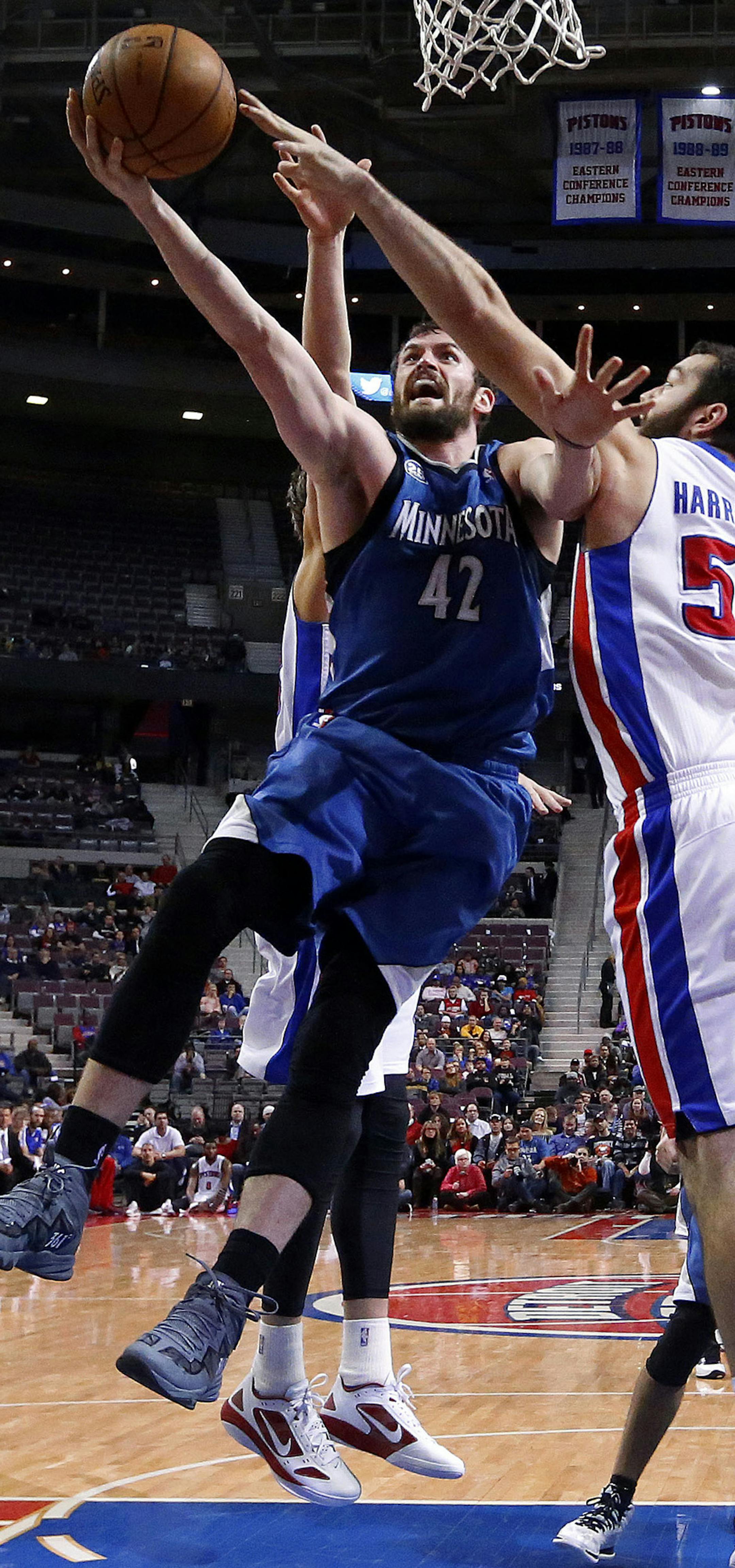 Minnesota Timberwolves power forward Kevin Love (42) drives on Detroit Pistons power forward Josh Harrellson (55) in the first half of an NBA basketball game in Auburn Hills, Mich., Tuesday, Dec. 10, 2013. (AP Photo/Paul Sancya)