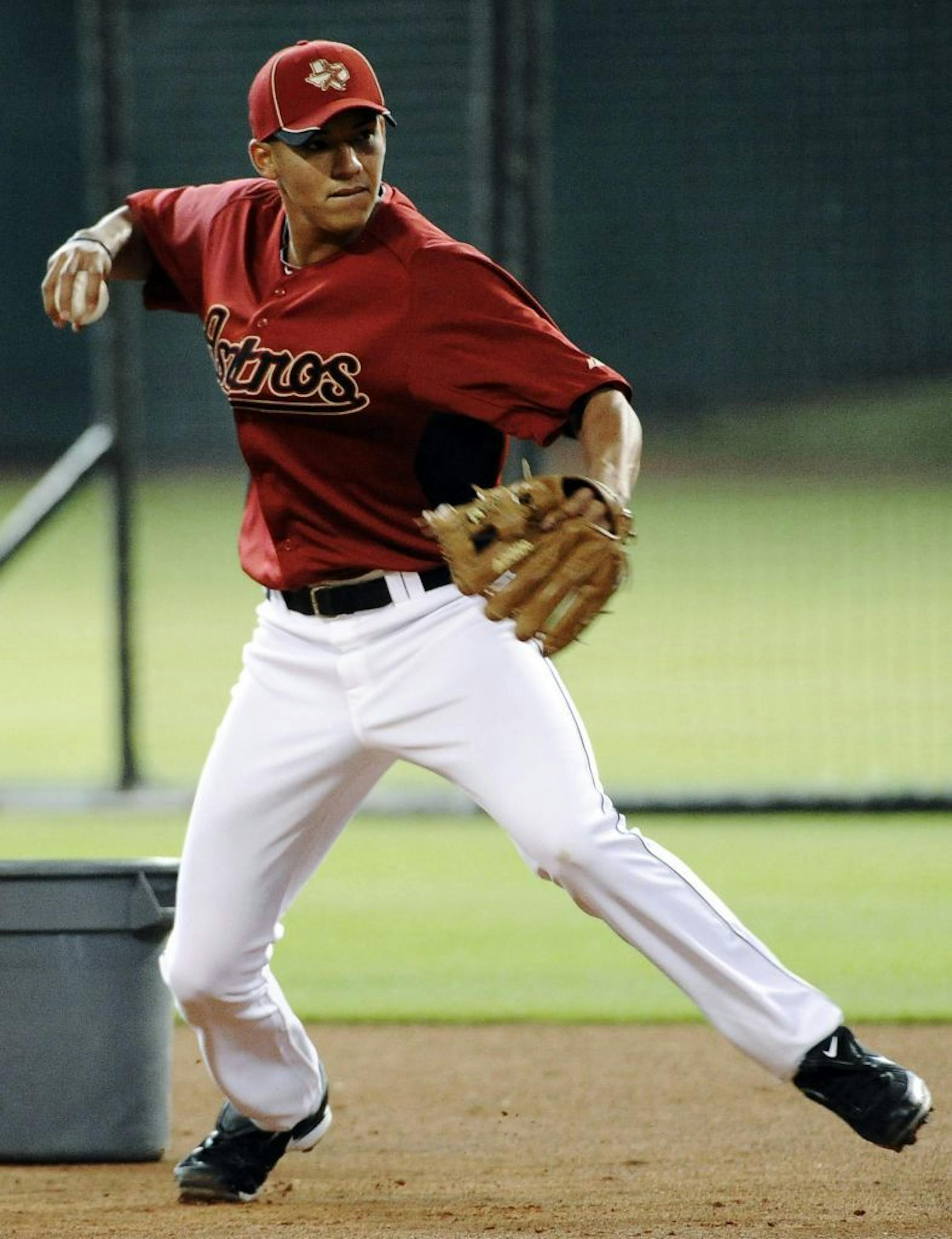 Major League Baseball's No. 1 draft pick Carlos Correa, 17, from Puerto Rico, participates in an infield drill after signing with the Houston Astros before a baseball game between the St. Louis Cardinals and the Astros, Thursday, June 7, 2012, in Houston.
