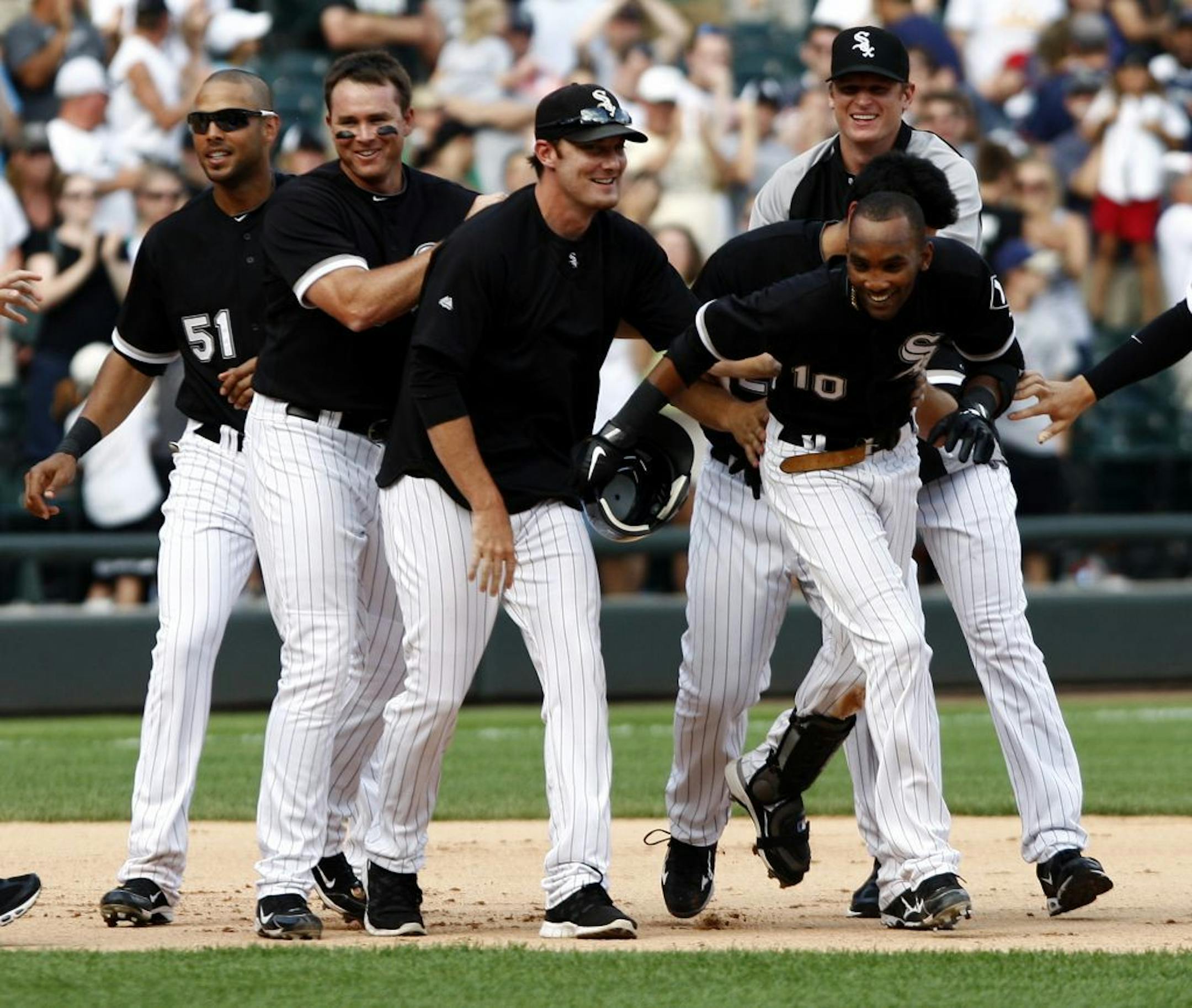 The Chicago White Sox's Alexei Ramirez was greeted by his teammates Saturday after bringing in the game-winning run against the Twins at US Cellular Field in Chicago.