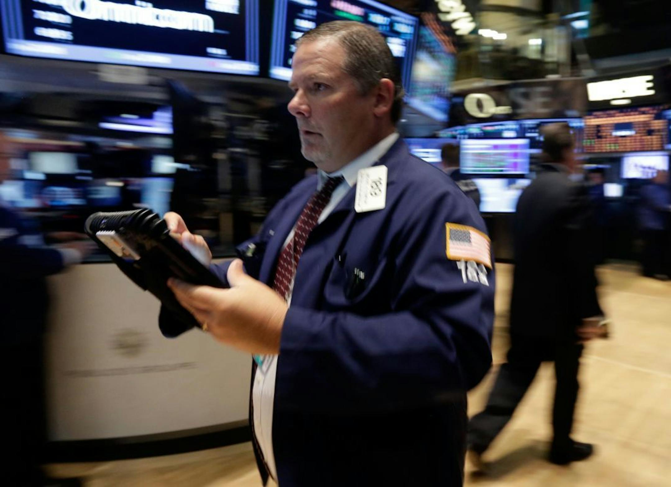 This July 29, 2013 photo, Trader Michael Conlon rushes across the floor of the New York Stock Exchange. U.S. stock futures rose modestly Tuesday, July 30, 2013, with most investors taking a wait-and-see approach ahead of a two-day Fed policy meeting.