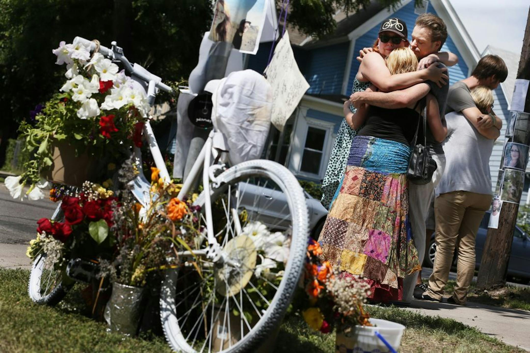 Co-workers Rachael Kopel left, John Blue, and Andrea Gardner hugged at the scene where Jessica Hanson was killed. Members of the police department and the family of 24-year old bicyclist Jessica Hanson, gathered at the site to talked about the arrest of a suspect Monday July 8, 2013 in Minneapolis, MN . Hanson died at 28th and Pleasant after being struck during an hit and run.