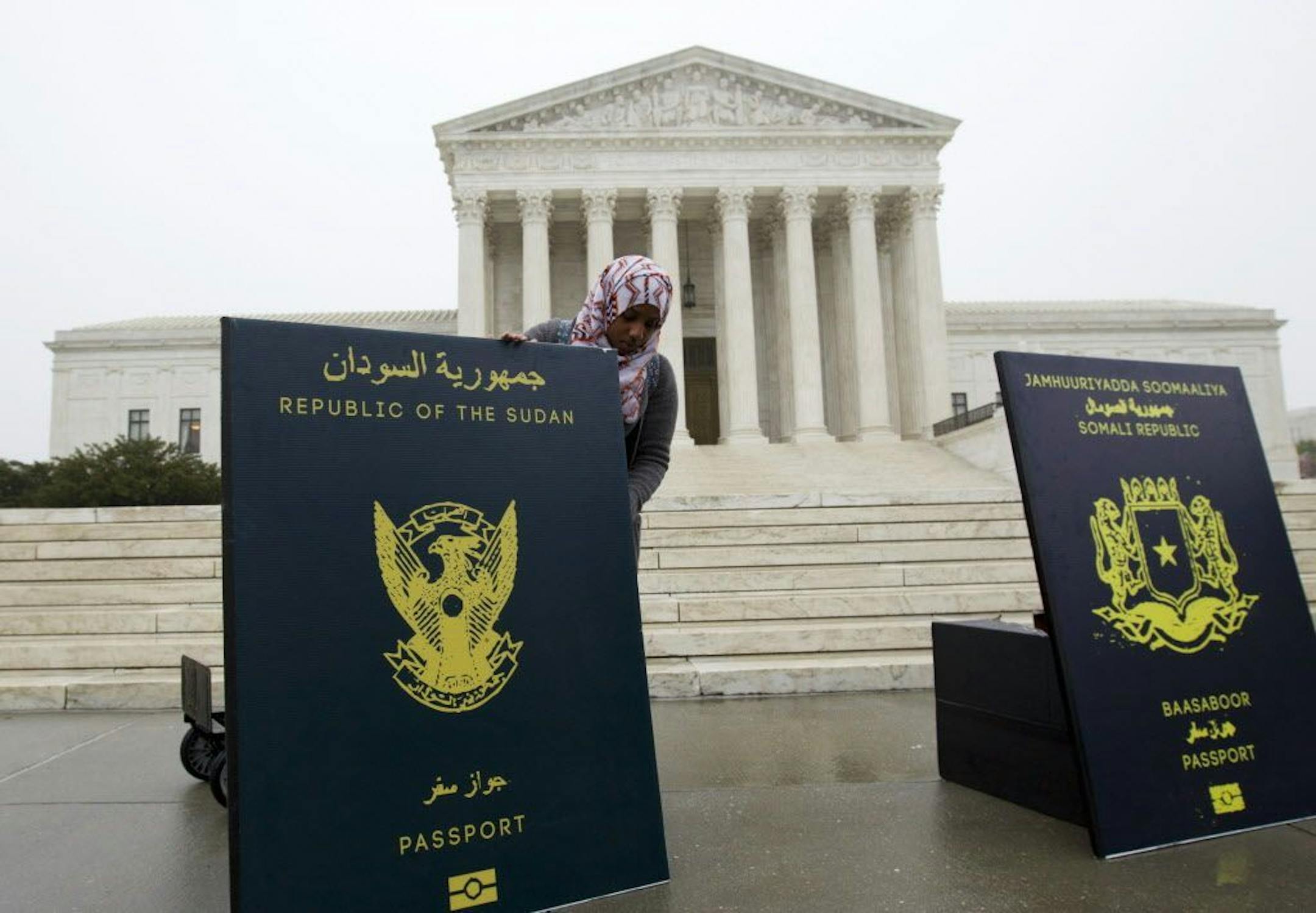 Poster-sized enlargements of passports were put on display outside the Supreme Court by people protesting President Trump's ban on visitors from certain foreign countries.