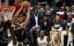 Kawhi Leonard, center, and Paul George, third from right, watch from the bench during the second half of the team's game against the Milwaukee Bucks o