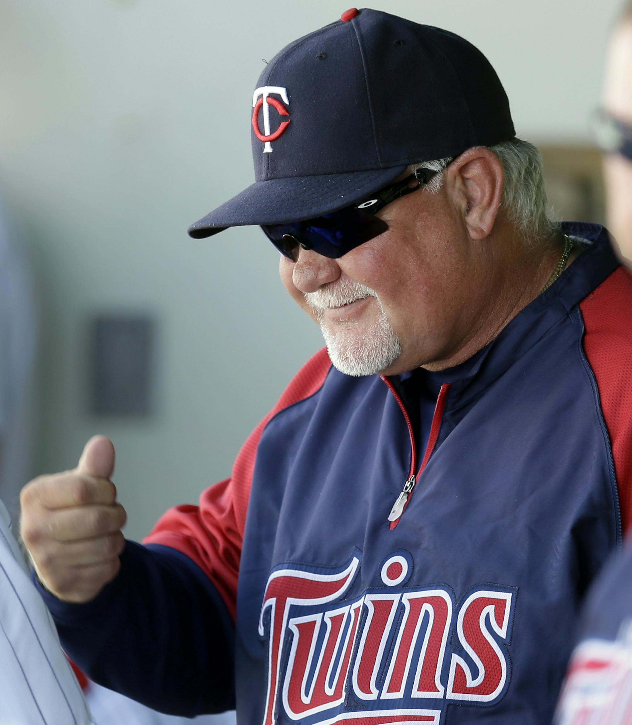 Minnesota Twins manager Ron Gardenhire smiles with players in the dugout in the ninth inning of an exhibition spring training baseball game against the Boston Red Sox in Fort Myers, Fla., Friday, March 29, 2013. The Twins won 8-3. (AP Photo/Elise Amendola)